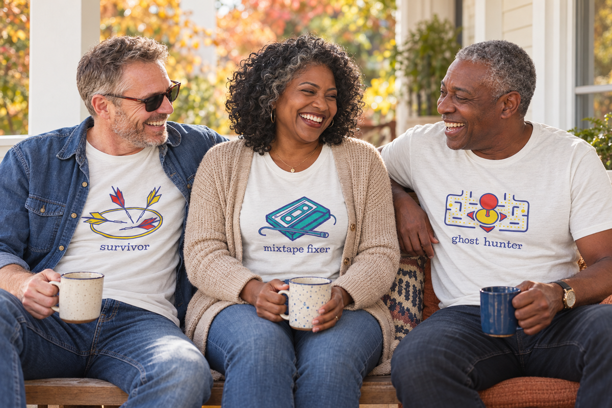 Three middle-aged friends laughing together on an autumn porch wearing nostalgic Hose Water Supply Co. T-shirts.